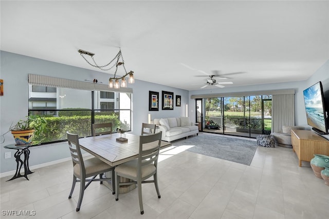 tiled dining area featuring ceiling fan with notable chandelier