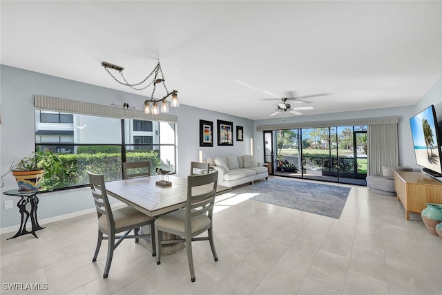 dining area featuring ceiling fan with notable chandelier and light tile patterned floors