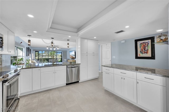 kitchen featuring decorative light fixtures, visible vents, appliances with stainless steel finishes, white cabinetry, and dark stone countertops