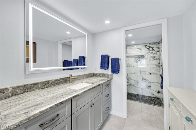 bathroom featuring vanity, a tile shower, and tile patterned flooring