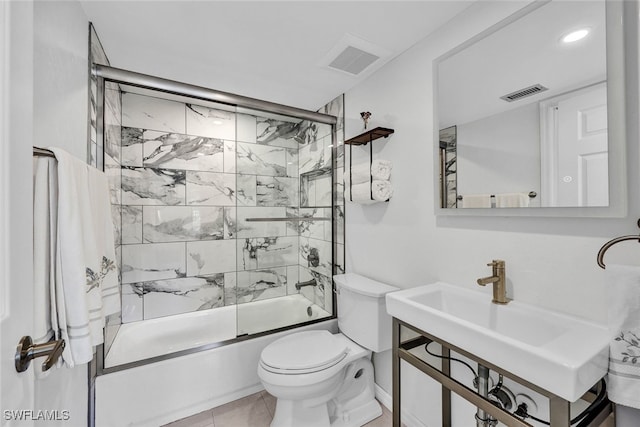 bathroom with visible vents, toilet, a sink, and combined bath / shower with glass door