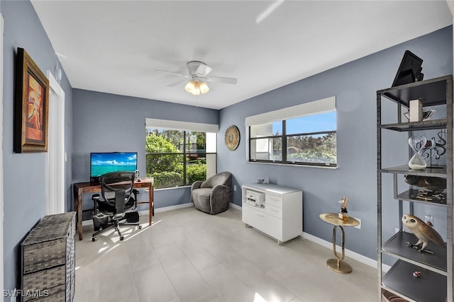 office space featuring a ceiling fan and baseboards