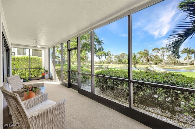 sunroom with a water view and ceiling fan