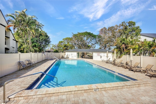 pool featuring fence and a patio