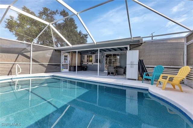 view of swimming pool featuring a patio area and a lanai