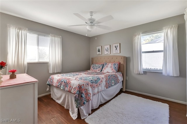 bedroom with multiple windows, ceiling fan, and dark wood-type flooring