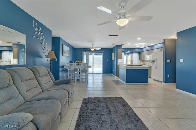 living room with ceiling fan and light tile patterned flooring