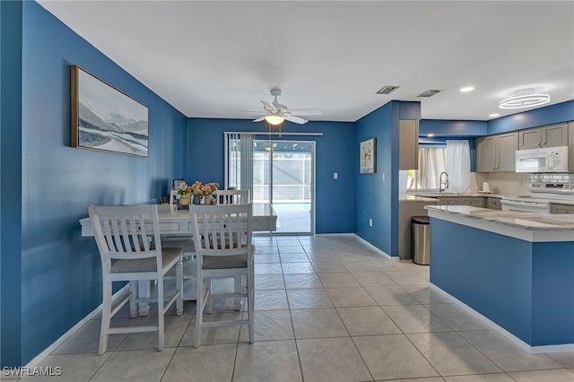 kitchen with electric range, ceiling fan, light tile patterned flooring, and sink