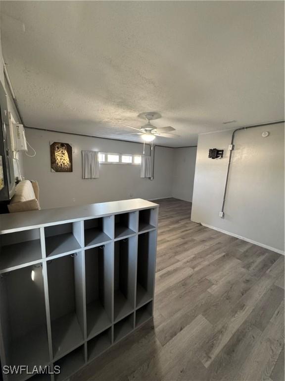 empty room with ceiling fan, a textured ceiling, and hardwood / wood-style flooring