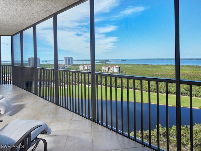 sunroom featuring a water view