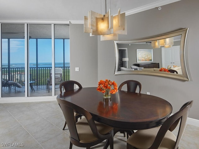 dining space featuring crown molding, light tile patterned flooring, a notable chandelier, and a water view