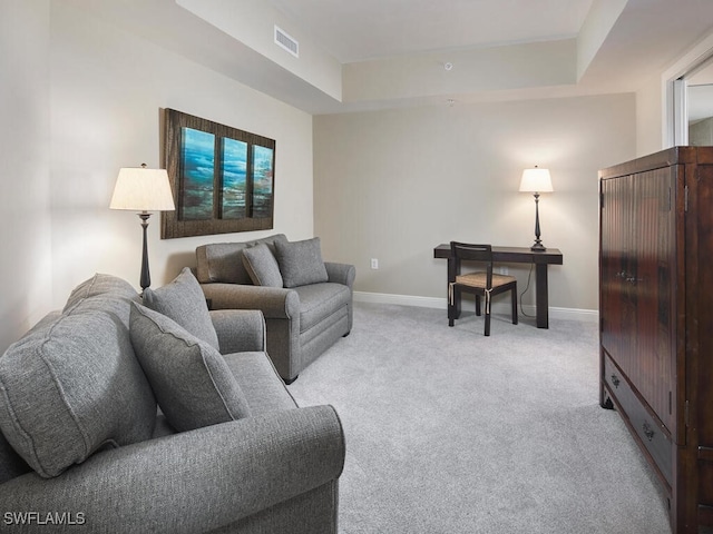 living room featuring light colored carpet and a raised ceiling