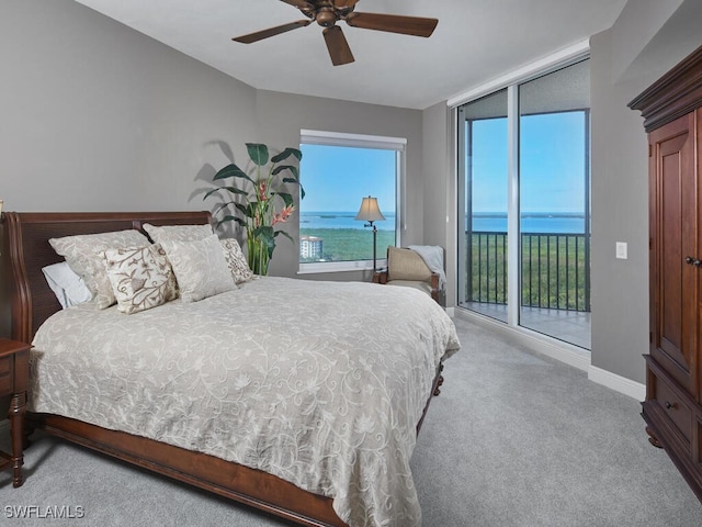 carpeted bedroom featuring a water view, ceiling fan, and access to outside