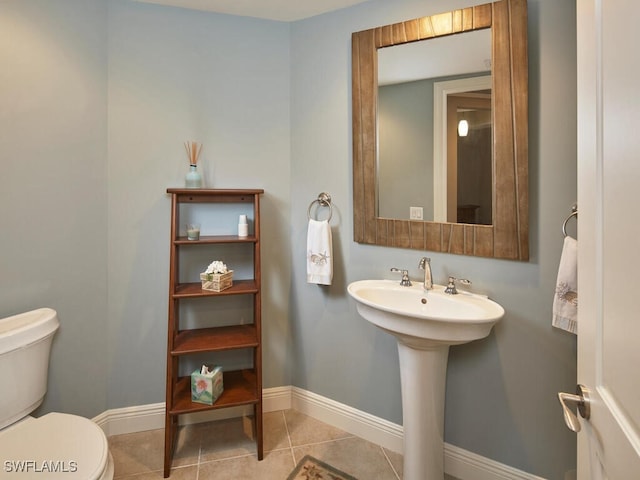 bathroom featuring toilet, sink, and tile patterned flooring