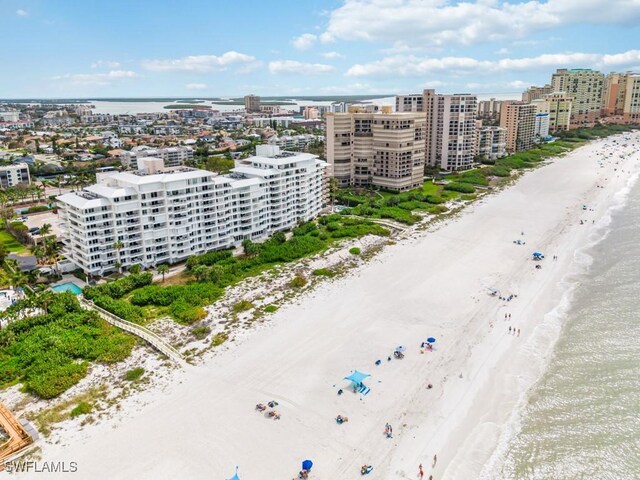 birds eye view of property with a water view and a beach view