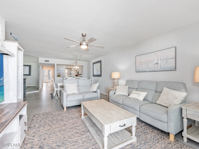 living room with ceiling fan with notable chandelier