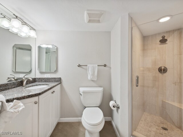 bathroom featuring vanity, toilet, and a shower with shower door