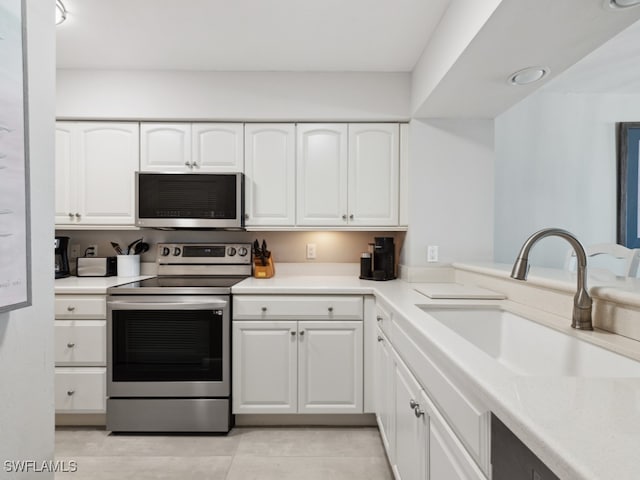 kitchen featuring appliances with stainless steel finishes, white cabinetry, and sink