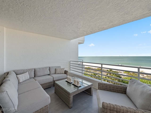 balcony featuring a view of the beach, an outdoor hangout area, and a water view