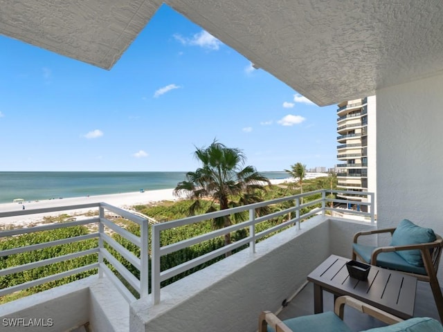 balcony featuring a water view and a view of the beach