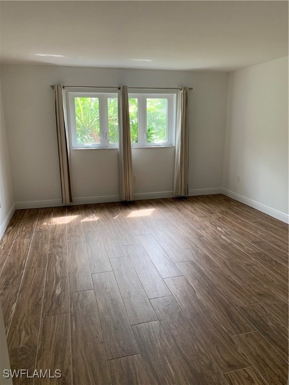 spare room featuring dark wood-type flooring