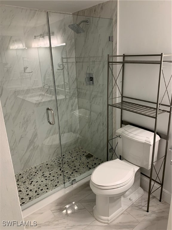 bathroom featuring toilet and a shower with shower door