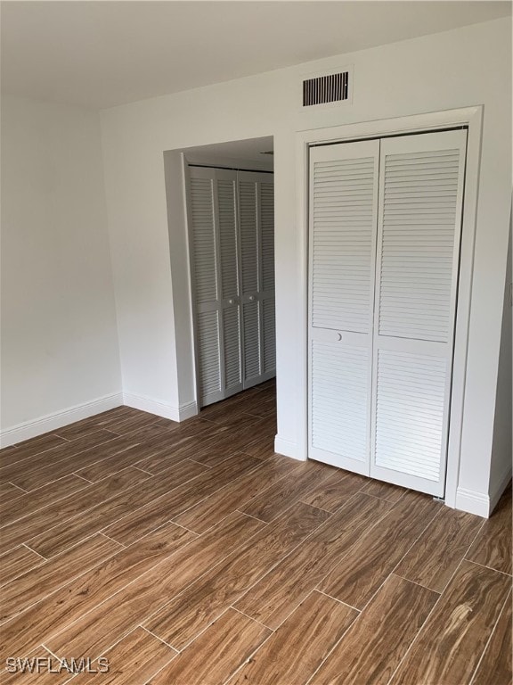 unfurnished bedroom featuring dark hardwood / wood-style flooring