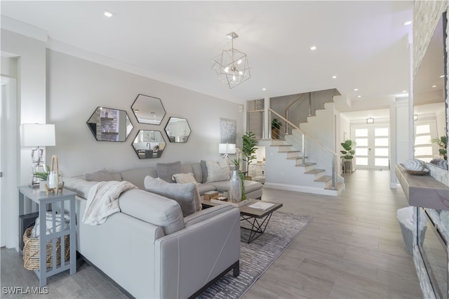 living room featuring crown molding, light hardwood / wood-style flooring, and a chandelier