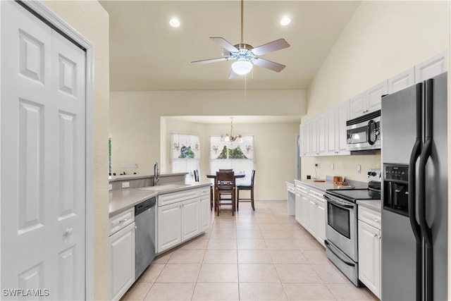 kitchen with white cabinetry, vaulted ceiling, stainless steel appliances, and sink