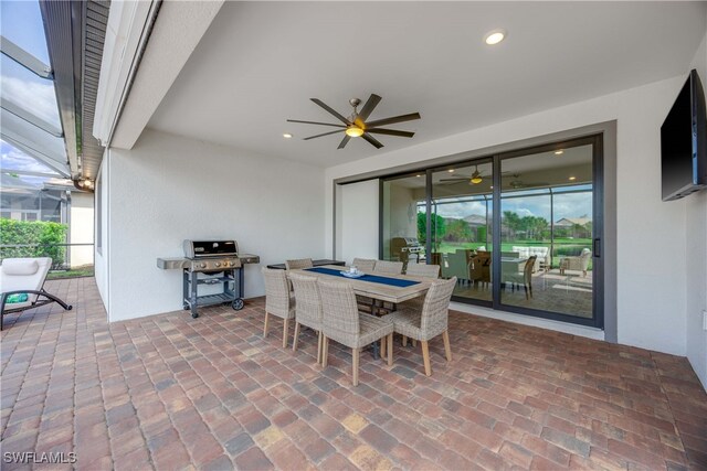 view of patio / terrace with area for grilling, ceiling fan, and glass enclosure