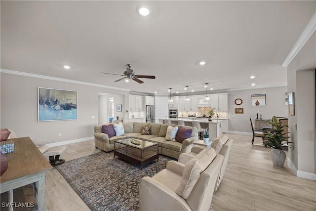 living room with ornamental molding, light wood-type flooring, and ceiling fan