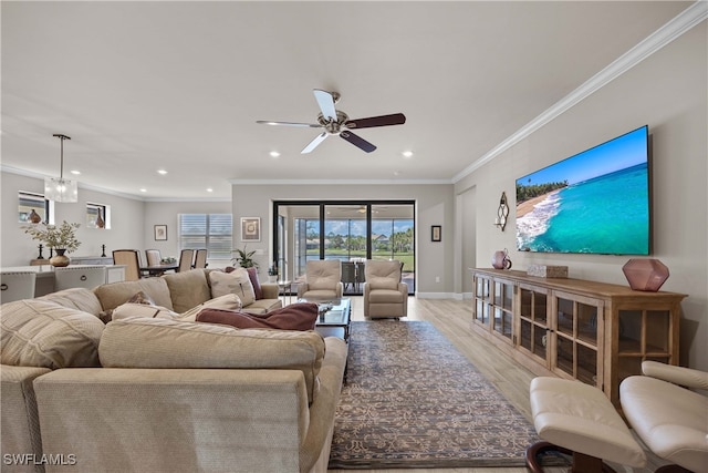 living room featuring crown molding, light wood-type flooring, and ceiling fan with notable chandelier