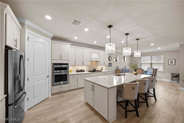 kitchen featuring white cabinets, decorative light fixtures, and stainless steel appliances