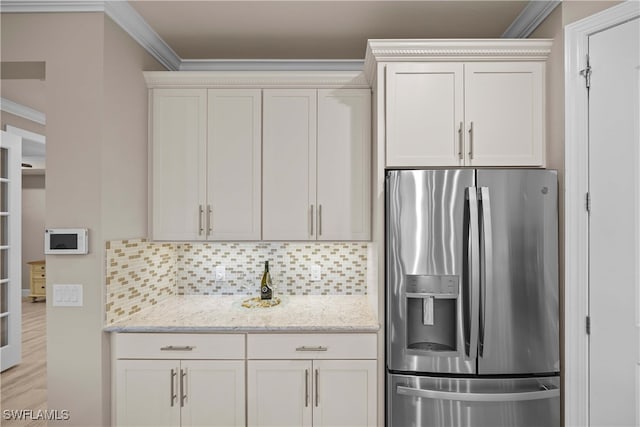 kitchen with crown molding, white cabinetry, and stainless steel refrigerator with ice dispenser