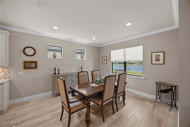 dining area featuring ornamental molding and light wood-type flooring