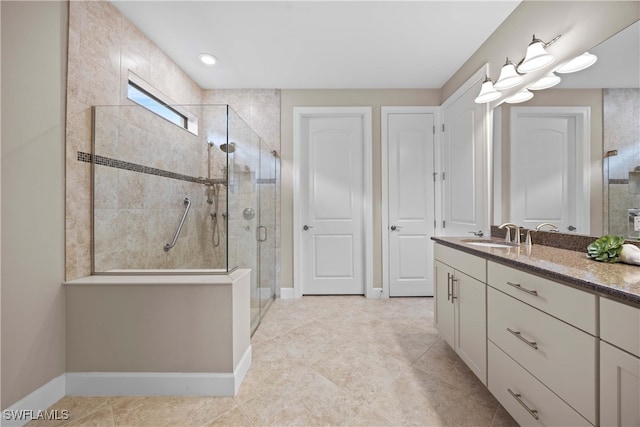 bathroom featuring vanity, a shower with shower door, and tile patterned floors