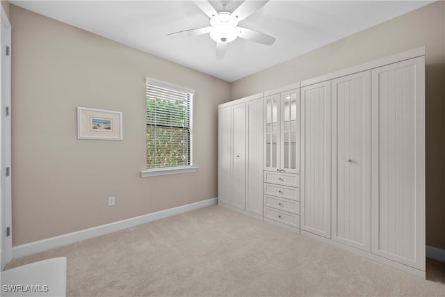 unfurnished bedroom featuring light carpet and ceiling fan