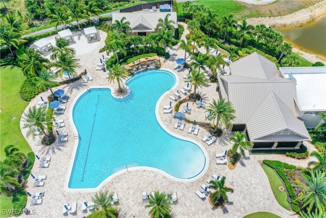 view of swimming pool with a patio area and a water view