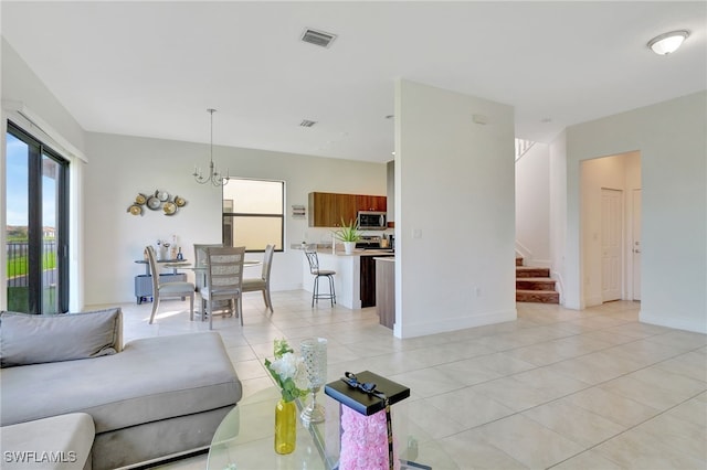 living room featuring light tile patterned flooring and an inviting chandelier