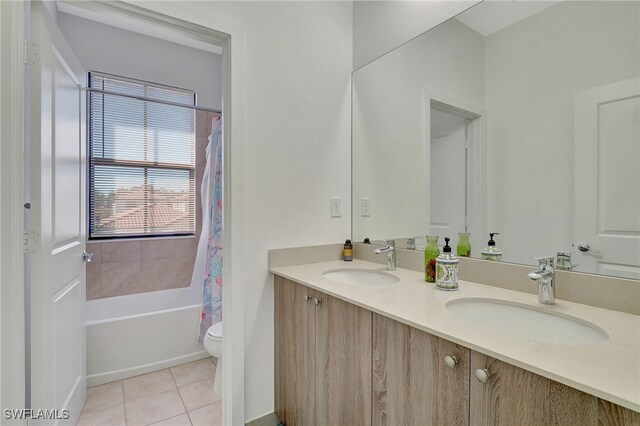 full bathroom with vanity, shower / bathtub combination with curtain, toilet, and tile patterned floors