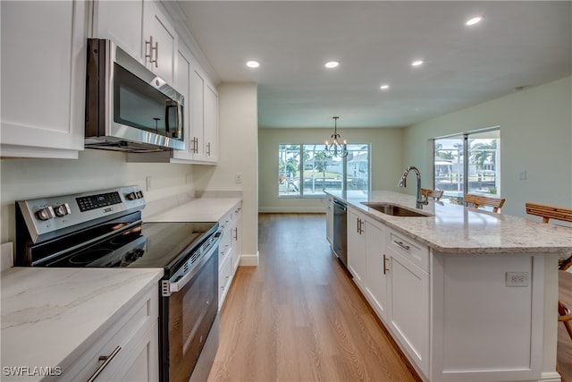 kitchen with white cabinetry, a center island with sink, stainless steel appliances, and sink