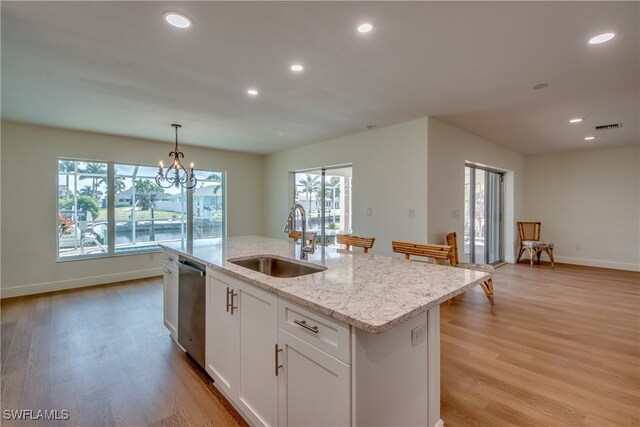 kitchen featuring stainless steel dishwasher, white cabinets, sink, and plenty of natural light