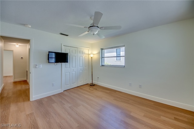 unfurnished bedroom featuring a closet, light wood-type flooring, and ceiling fan