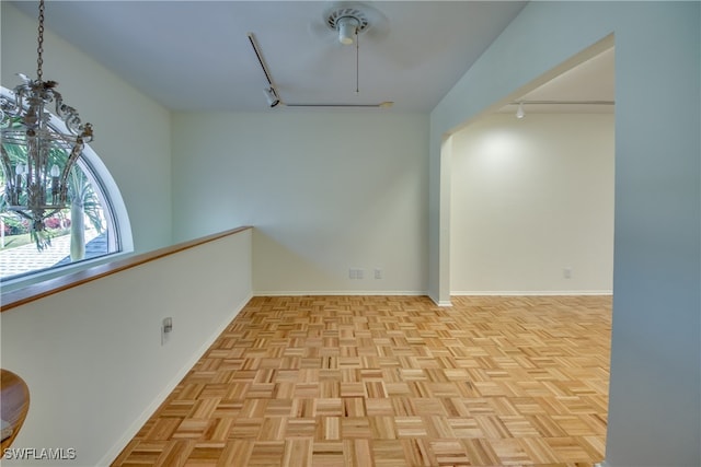 empty room with rail lighting and light parquet flooring