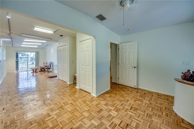 empty room with vaulted ceiling and light parquet floors