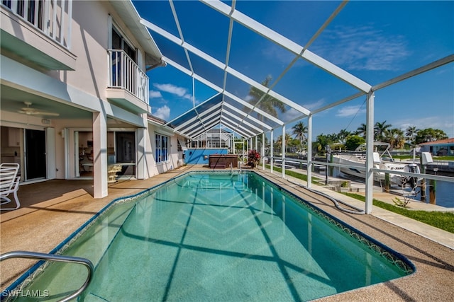 view of swimming pool featuring a water view, a patio, and a lanai