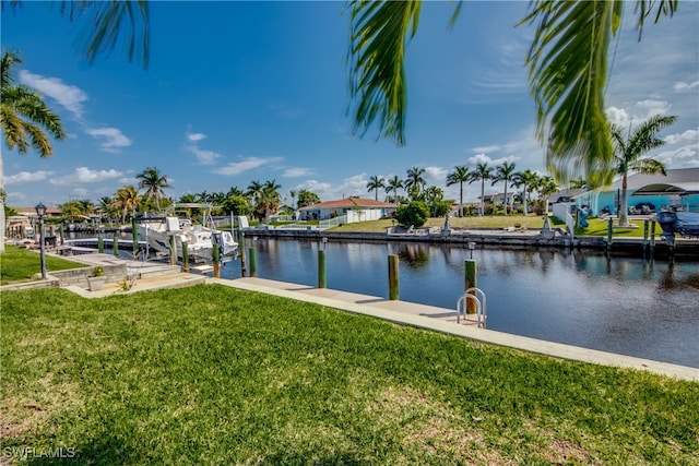 view of dock with a lawn and a water view