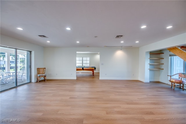 unfurnished living room with light wood-type flooring and pool table