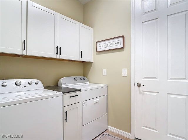 clothes washing area with washing machine and dryer and cabinets