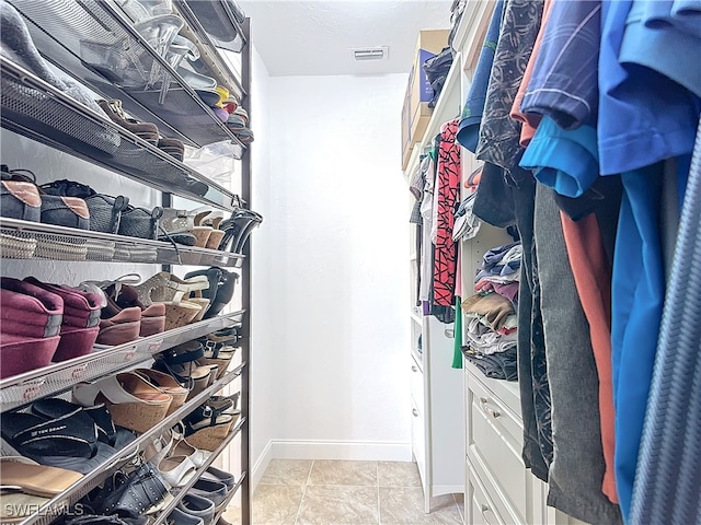 spacious closet with light tile patterned floors